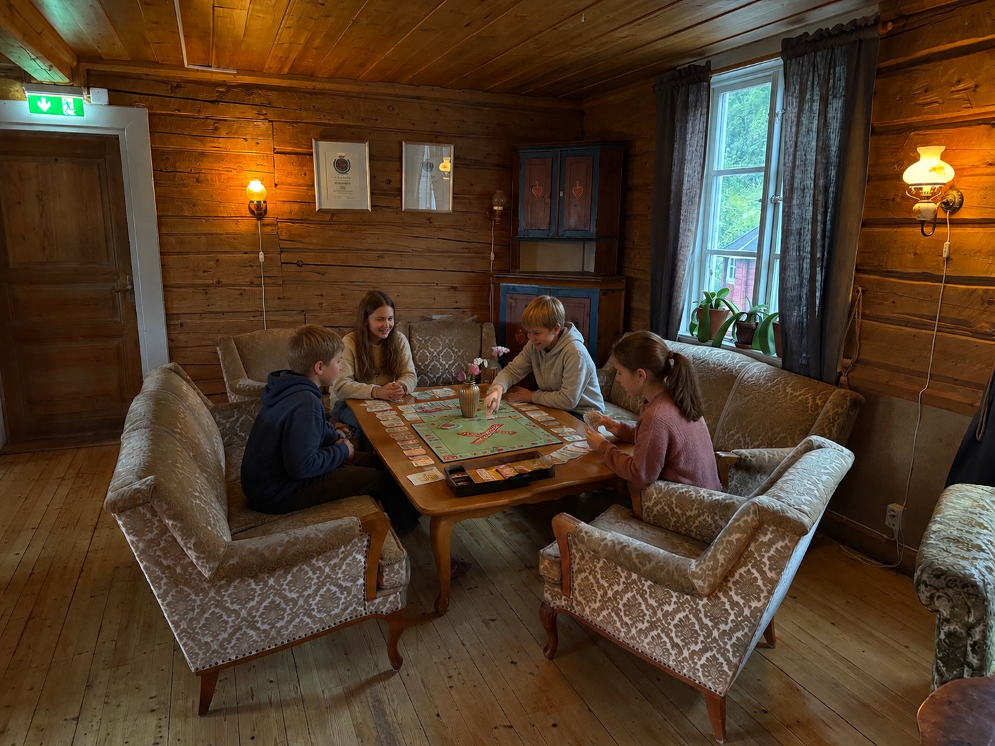 Barn spelar brädspel tillsammans i stua på Sånninggården